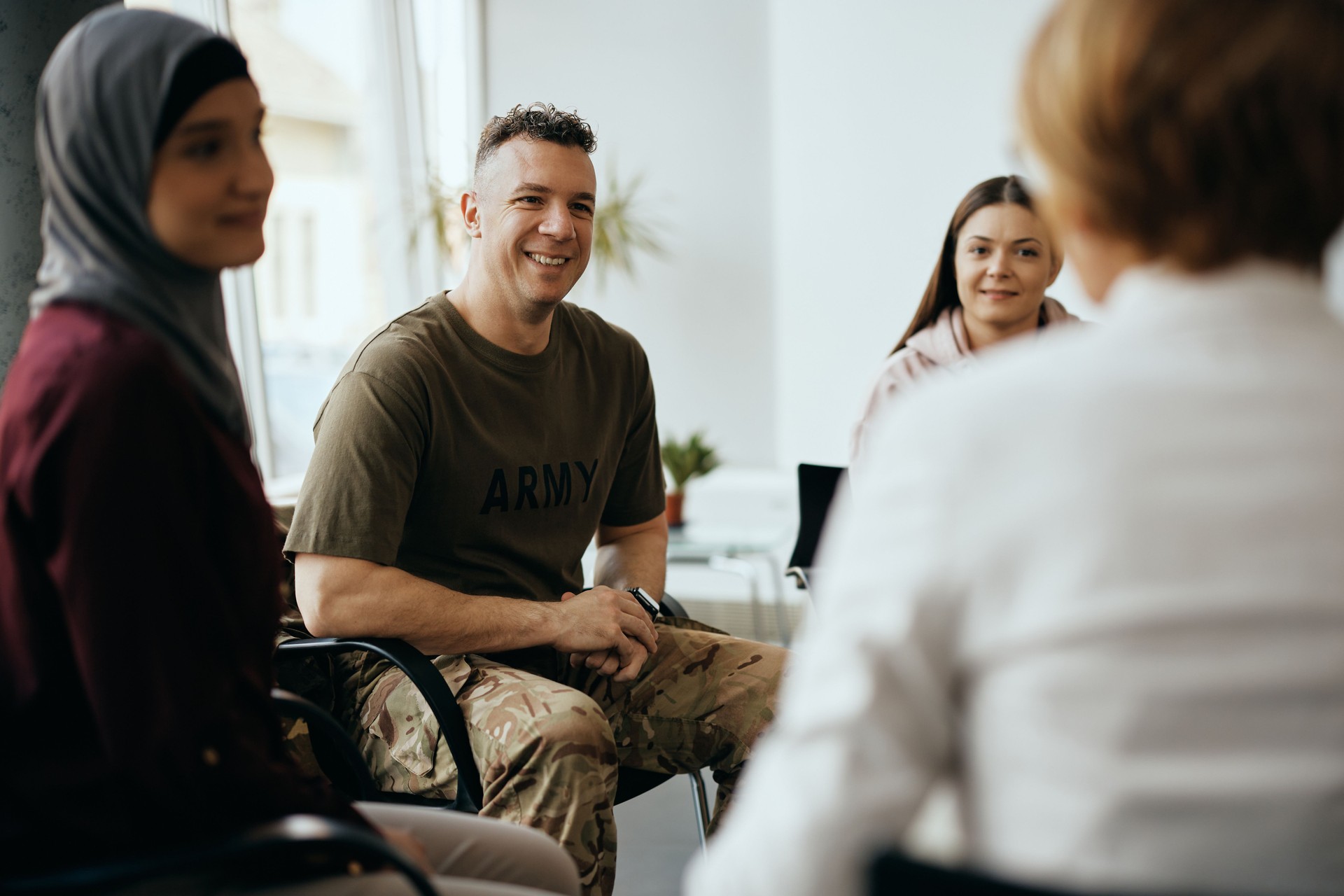Happy military man attending group therapy at community center.